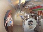  Here is Susan near an exhibit of a break in CERN's LHC ring. The two brass discs that form the "eyes"   in  the end of the tube are the cross section of the two actual accelerator tubes,  one in each direction.  Particles travel in a penny-sized hole through these tubes.
